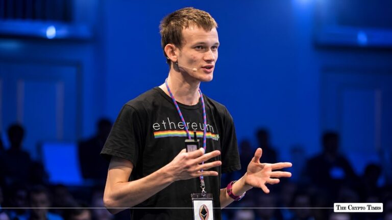 Vitalik Buterin speaking on stage while wearing a black Ethereum t-shirt.