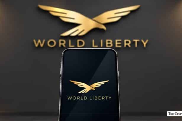 World Liberty logo displayed on a smartphone in front of a matching wall sign.