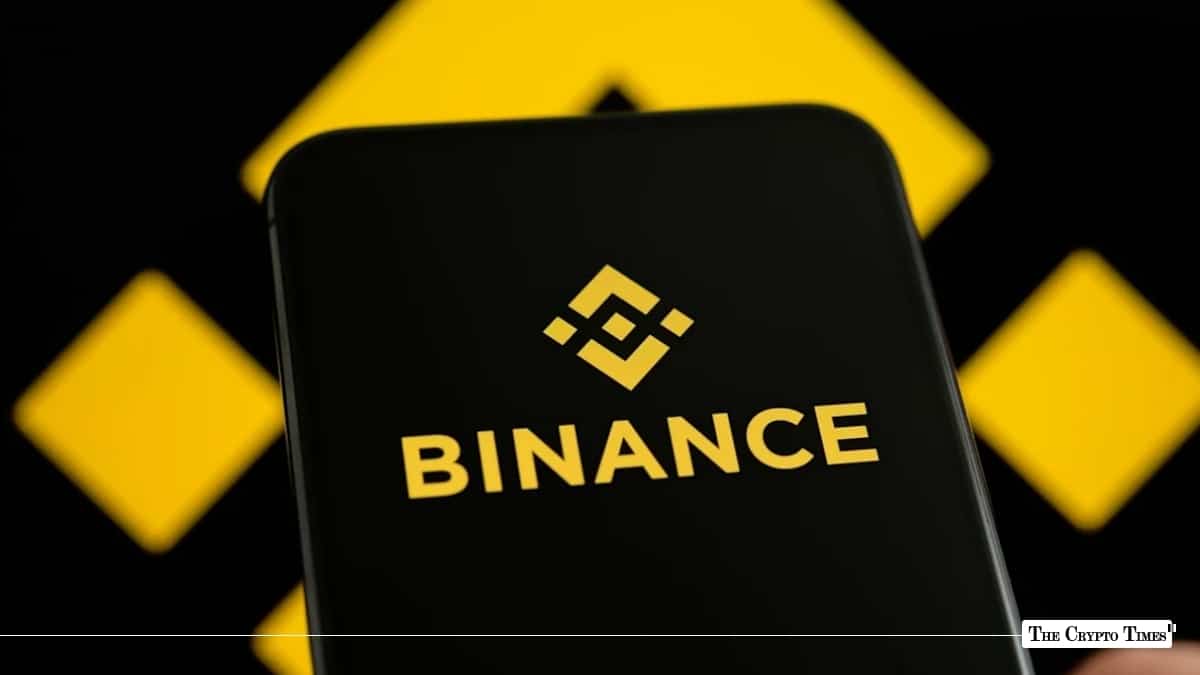 Smartphone screen displaying the yellow Binance logo and wordmark against a blurred geometric background