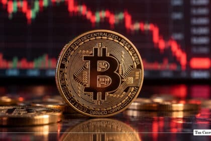 Gold Bitcoin coin in front of a red market chart