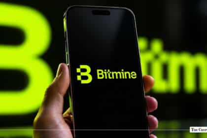 Hand holding a smartphone displaying the Bitmine mobile application logo against a neon green corporate backdrop