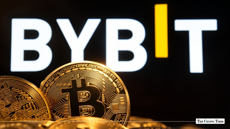 Physical gold Bitcoin coins in front of a brightly lit white and yellow Bybit logo on a dark background.