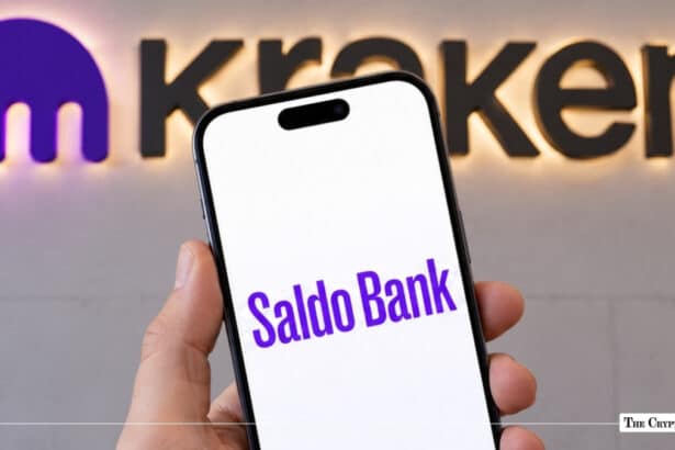 Smartphone displaying Saldo Bank logo in front of Kraken wall sign