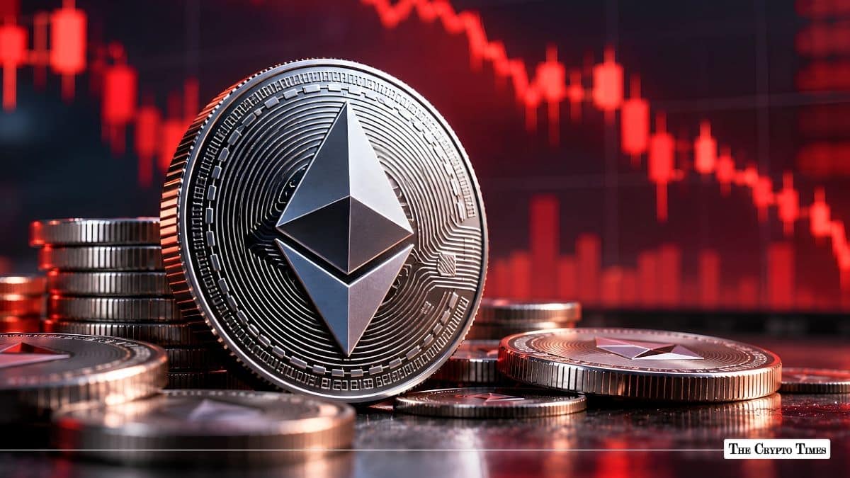Physical silver Ethereum coin standing in front of a red declining market chart.