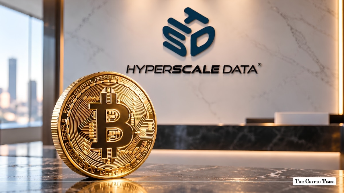 Physical gold Bitcoin coin standing on a table in front of a Hyperscale Data office wall.