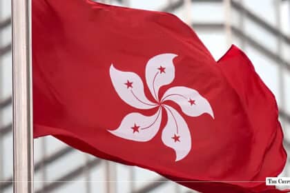 Hong Kong flag waving near financial district skyscraper representing crypto regulation hub