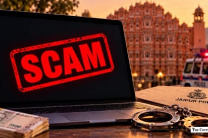 Laptop with red SCAM warning text next to Jaipur Police folder, handcuffs, Indian Rupee notes, and Hawa Mahal background