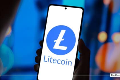 Hand holding a smartphone displaying the blue and white Litecoin (LTC) logo on screen