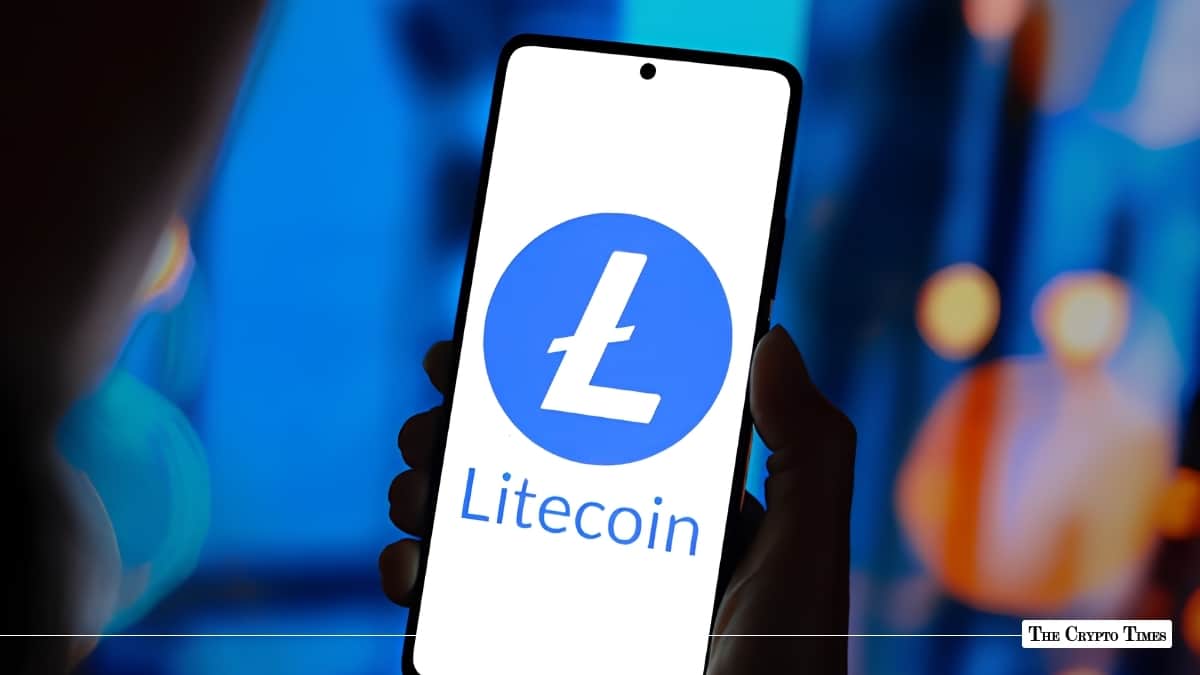Hand holding a smartphone displaying the blue and white Litecoin (LTC) logo on screen