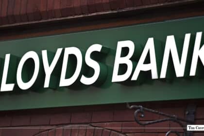 White dimensional Lloyds Bank signage mounted on a green storefront fascia over brickwork