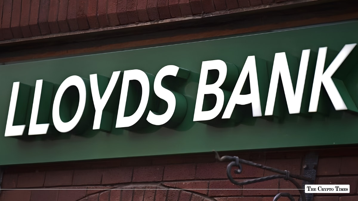 White dimensional Lloyds Bank signage mounted on a green storefront fascia over brickwork