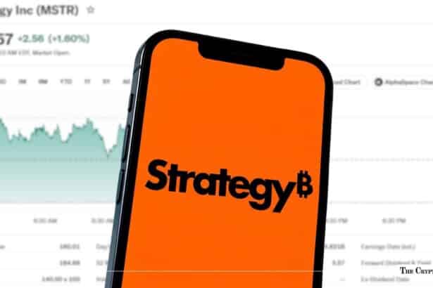 Smartphone displaying the MicroStrategy "Strategy" logo on an orange background in front of a stock market price chart.
