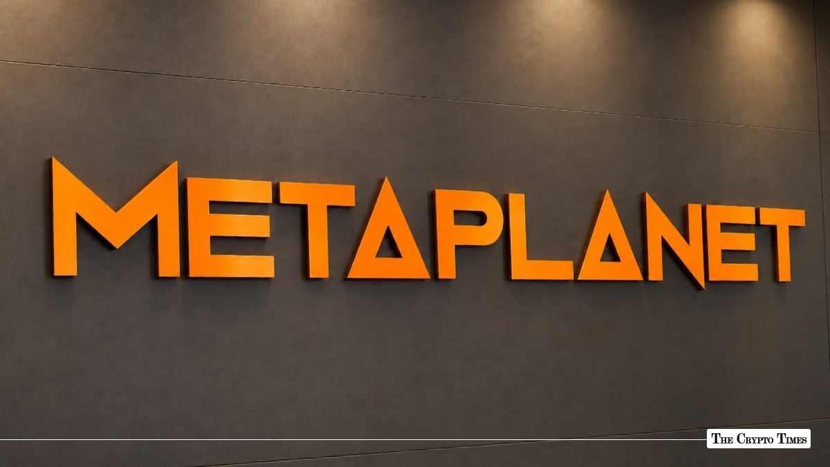 Orange 3D Metaplanet logo mounted on a dark grey corporate office wall