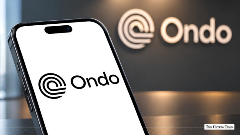 Smartphone displaying the Ondo Finance logo in front of Ondo wall signage.