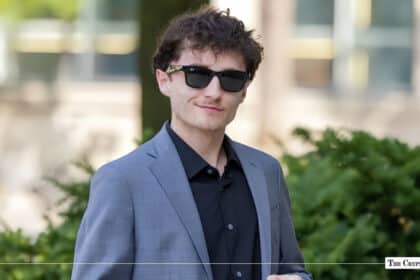 Portrait of Aiden Pleterski wearing sunglasses and a grey suit jacket