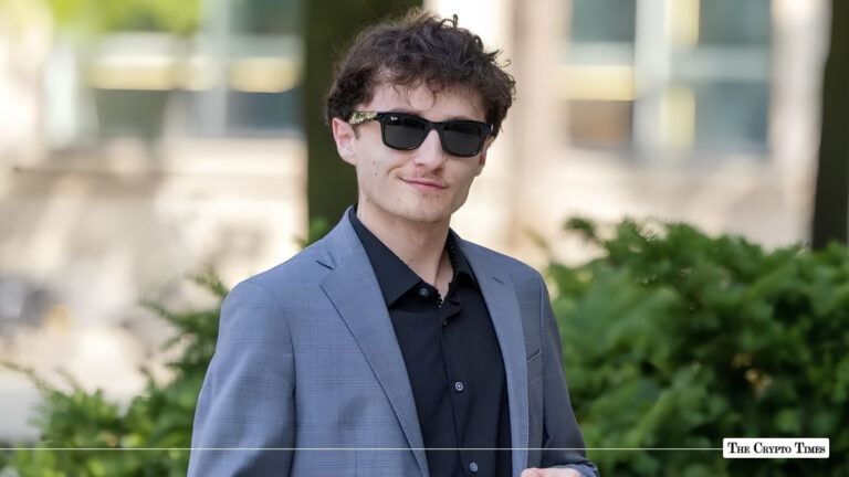 Portrait of Aiden Pleterski wearing sunglasses and a grey suit jacket