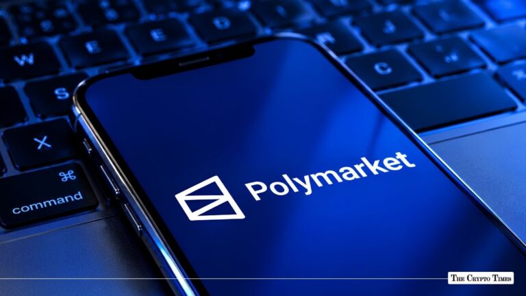 Smartphone displaying the Polymarket logo resting on a laptop keyboard.
