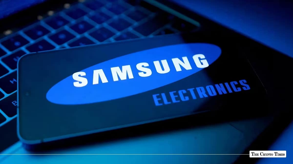 Smartphone screen displaying the Samsung Electronics logo resting on a illuminated laptop keyboard