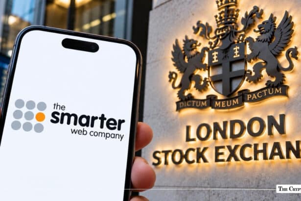 Smartphone with The Smarter Web Company logo held before the London Stock Exchange sign