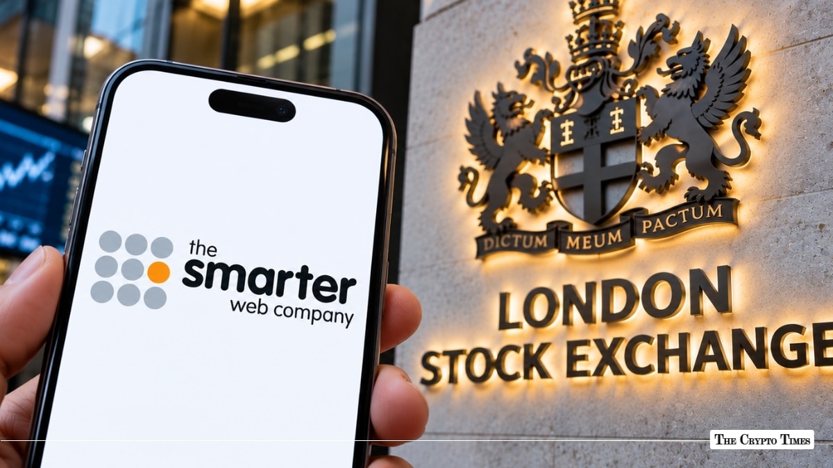 Smartphone with The Smarter Web Company logo held before the London Stock Exchange sign