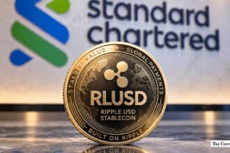 Ripple USD (RLUSD) stablecoin coin in front of Standard Chartered logo