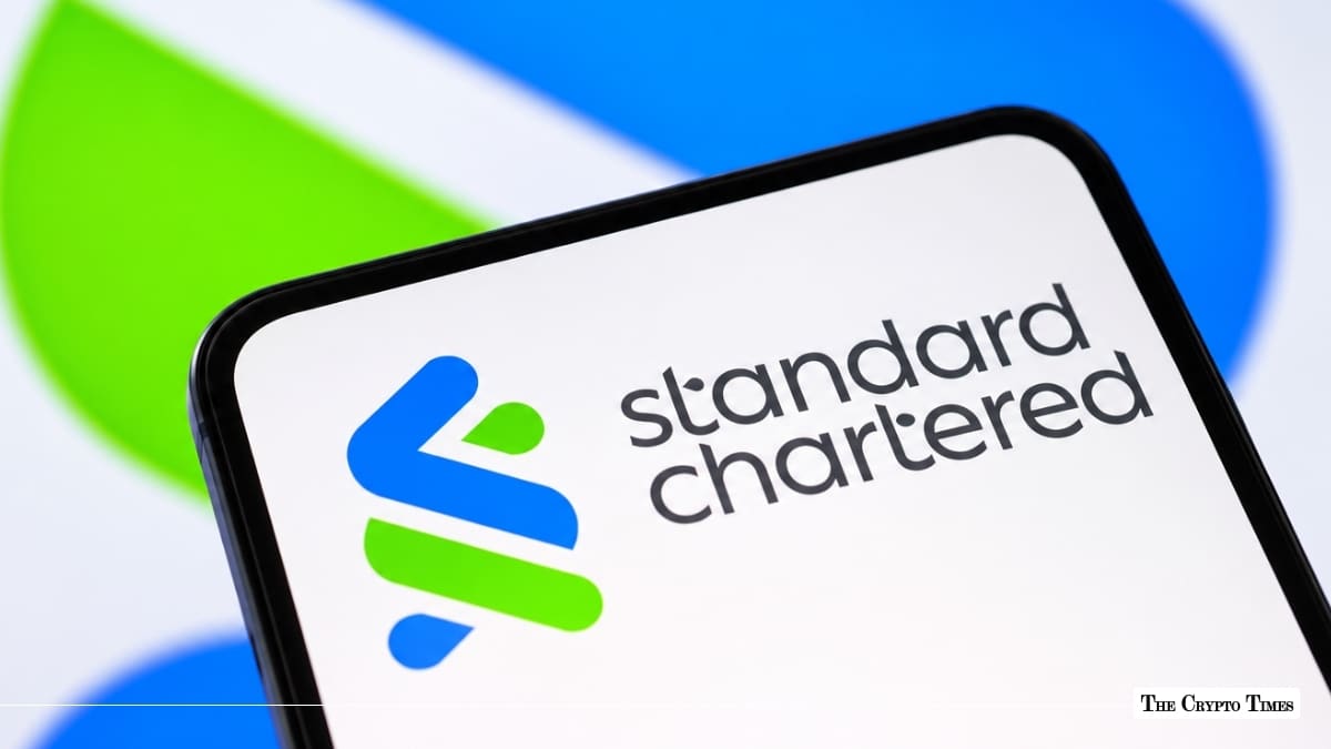 Smartphone screen displaying the blue and green Standard Chartered logo and wordmark against a blurred corporate backdrop