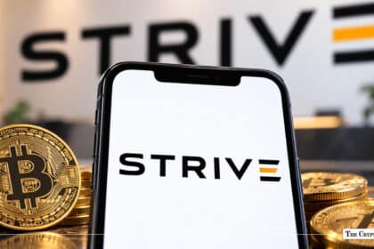 Smartphone displaying the Strive logo next to physical Bitcoin coins