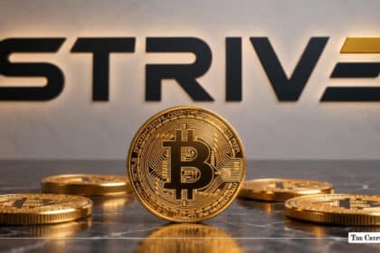 Physical Bitcoin token standing on a dark marble surface in front of the Strive corporate logo