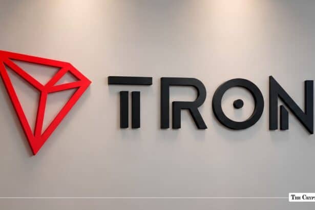 Red TRON geometric logo alongside black 3D TRON typography mounted on a light grey wall.