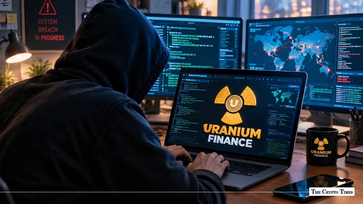 Hooded hacker working on a laptop displaying Uranium Finance branding next to a system breach alert.