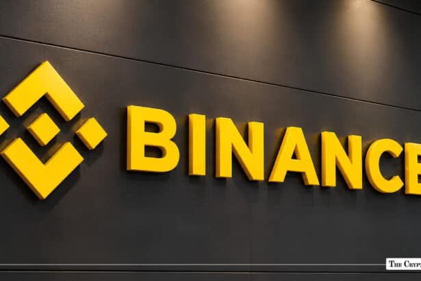 Yellow Binance logo and bold wordmark mounted on a dark charcoal corporate wall.