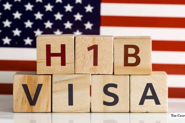 Wooden blocks spelling "H1B VISA" stacked in front of the flag of the United States