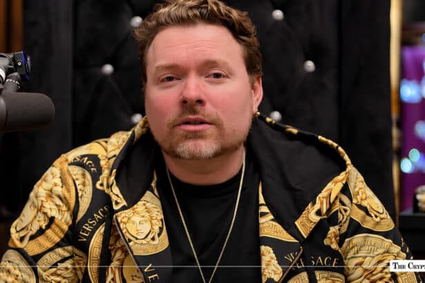 HEX founder Richard Heart wearing a gold patterned Versace hoodie during an interview