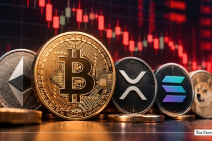 Physical Ethereum, Bitcoin, XRP, Solana, and Dogecoin coins in front of a red market chart